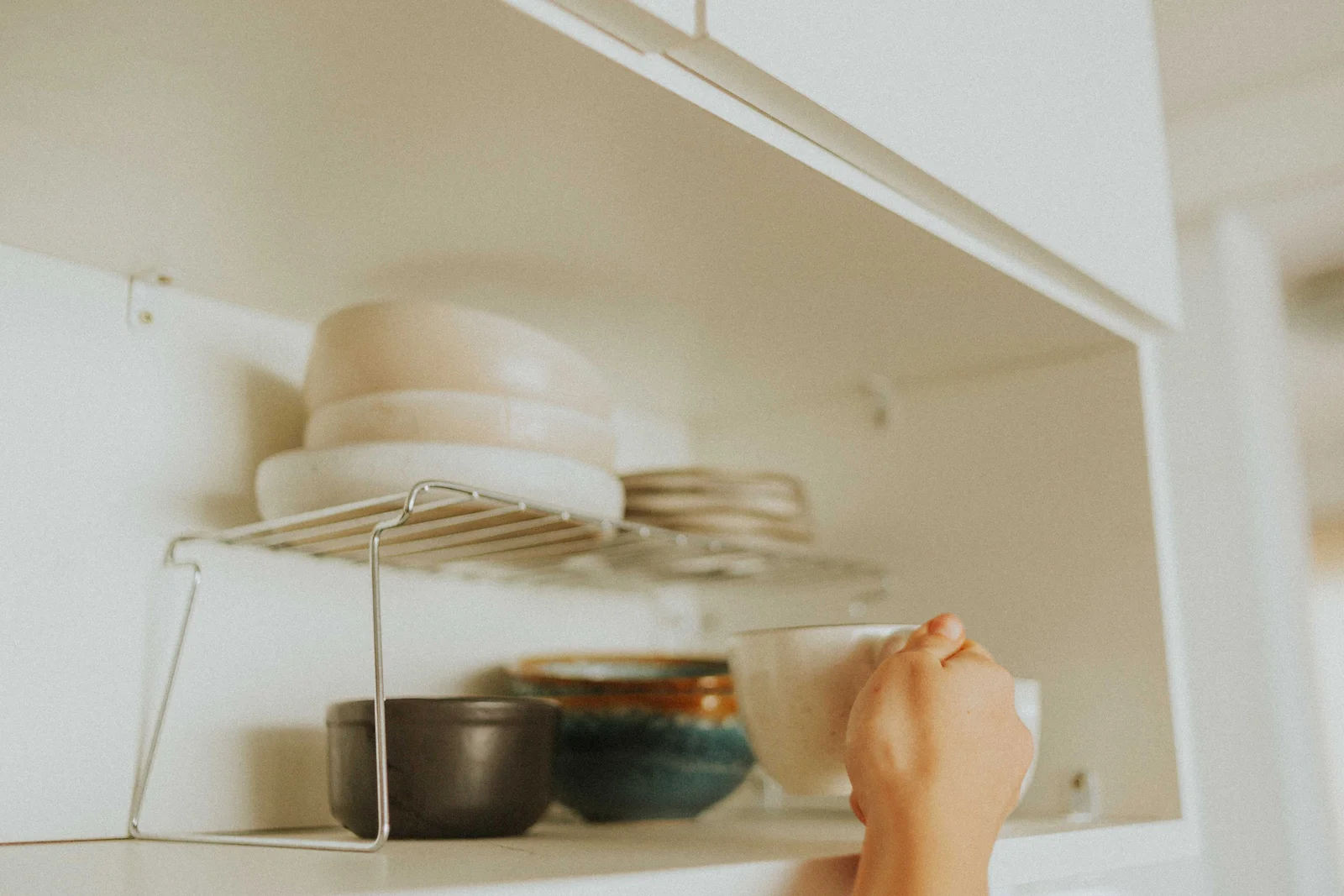 Meuble haut de cuisine fixé au mur, étagères chargées de piles d'assiettes