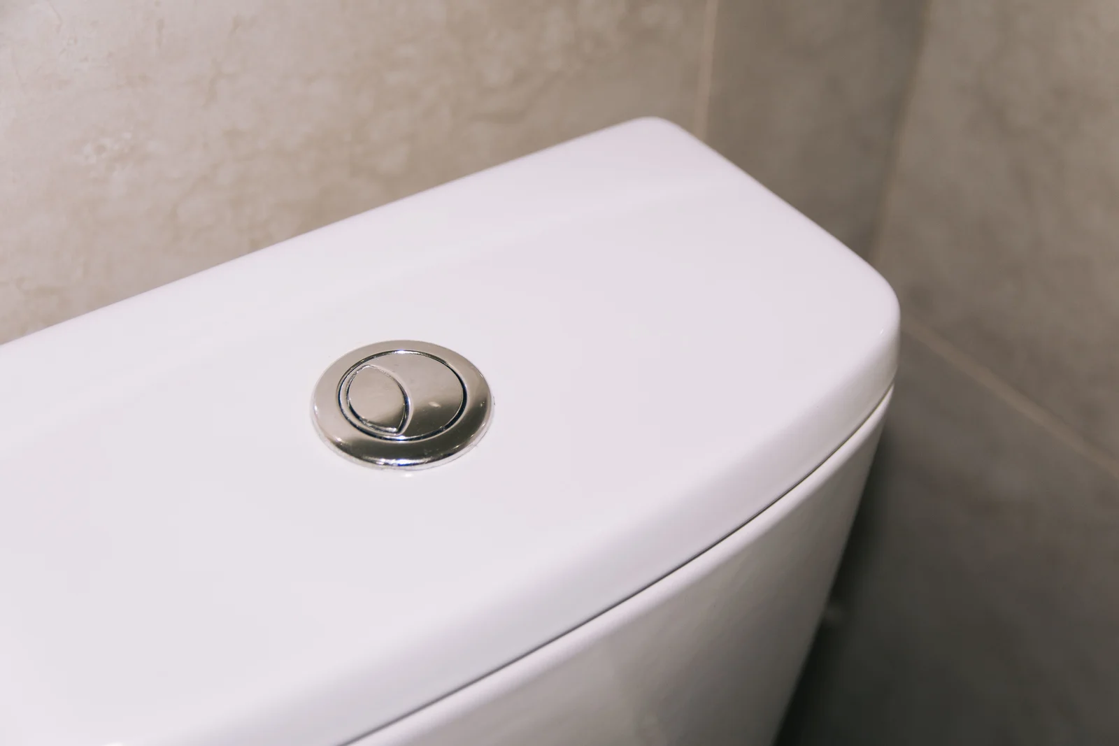 Bouton poussoir double commande sur le couvercle d'un réservoir de chasse d'eau